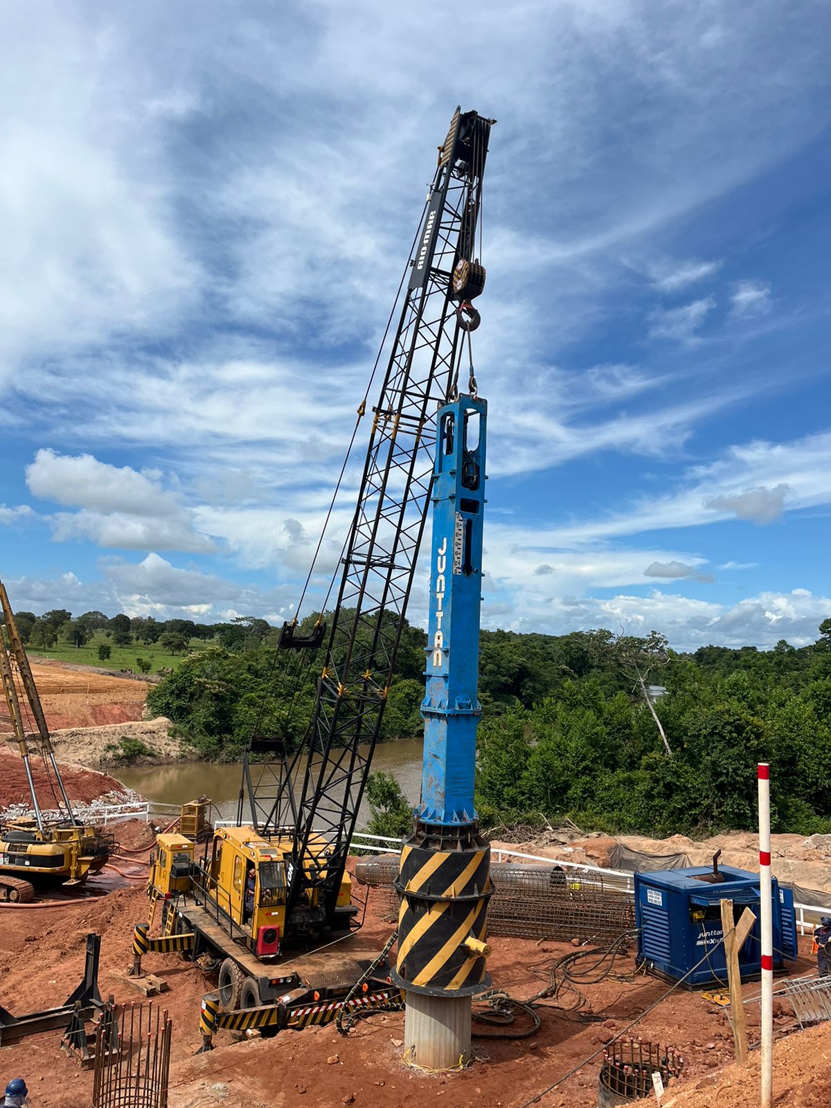 Martelo hidráulico de grande porte sendo usado em ensaio PDA para fundações de obra de infraestrutura.